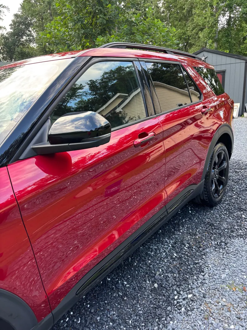 Red Ford Explorer in profile, door and window trim polished to a deep gloss