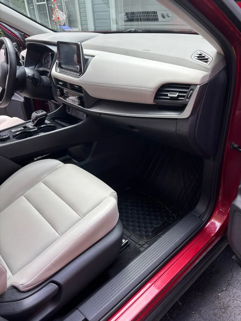 Passenger side of a red sedan with a cream dashboard and seats, cleaned and conditioned