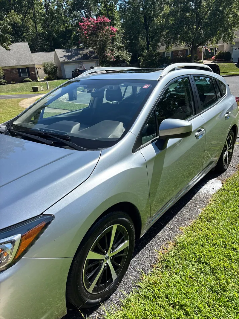 Silver Subaru Impreza hatchback in a driveway, paint washed and glass cleaned