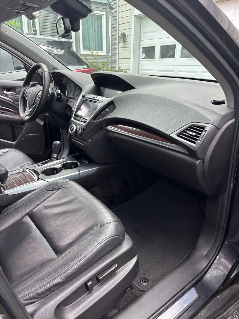 Passenger side of the Acura MDX dashboard and footwell, wood trim wiped down